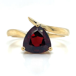A 9ct yellow gold ring with a trillion cut garnet gemstone.