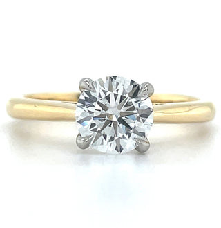 An 18ct yellow gold band with a central laboratory-grown round brilliant cut diamond held by platinum claws. Engagement ring